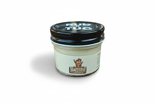 Cartoon-style logo for “Knotty” featuring a mischievous, grinning tree stump character with jagged edges, arched brows, and expressive eyes. The character clutches a horizontal wooden plank sign that reads “KNOTTY” in bold, cream-colored block letters. The entire logo is set on a white background, creating a bold contrast and playful, high-impact look.
Ideal for natural men’s hair pomade branding, cheeky grooming product lines, barbershop-themed styling cream logos, and SEO-rich marketing for org