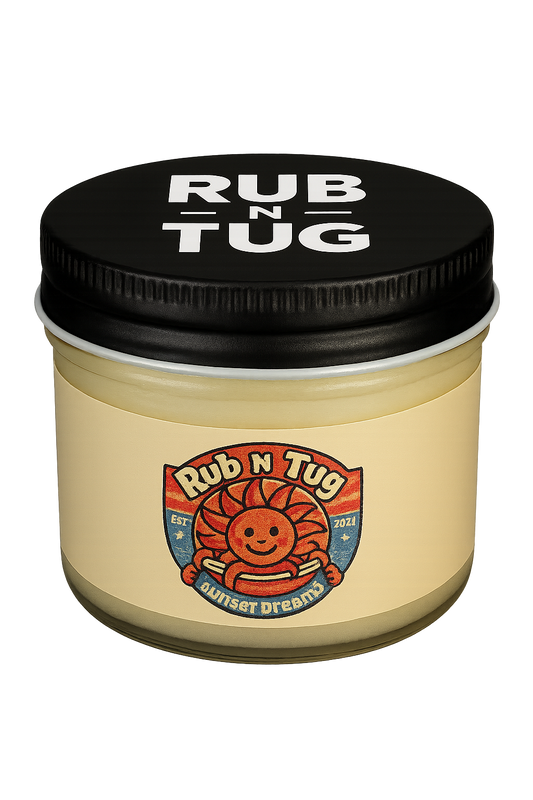 A clear glass jar of Rub N Tug pomade labeled “Sunset Dreams,” topped with a black screw-on lid featuring bold white “RUB N TUG” lettering. The label showcases a cheerful, cartoon-style sun with barber pole arms in red, white, and blue tones, evoking a vintage Americana vibe.  Natural men’s hair pomade, veteran-owned, 4th generation barber-approved, all-natural ingredients, strong hold, classic finish, Rub N Tug grooming products USA.