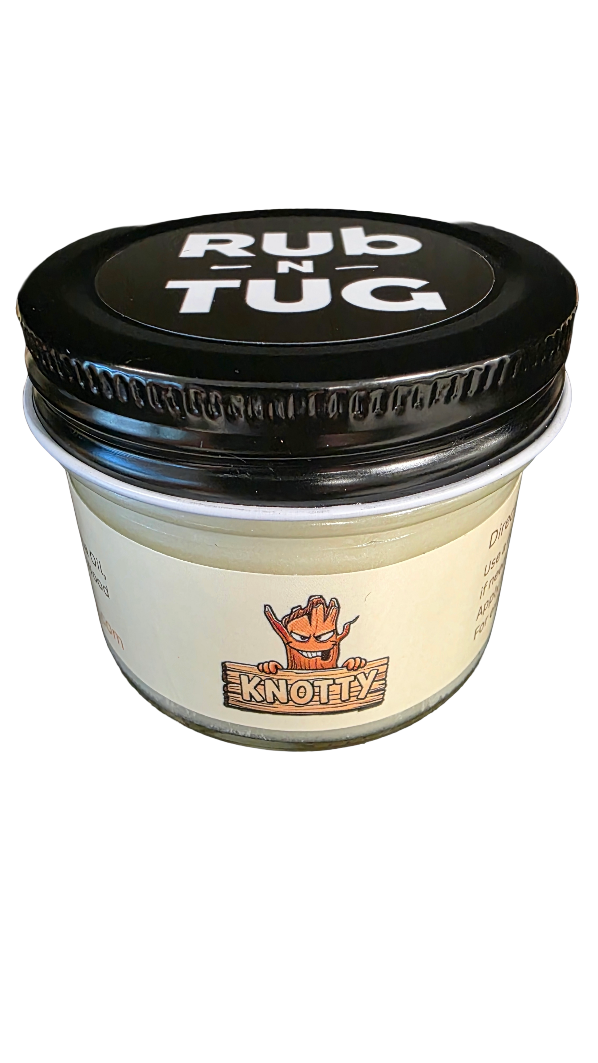 Photograph of a cylindrical glass jar of Rub N Tug pomade with a black lid displaying bold white text that reads “Rub N Tug.” The label features the “Knotty” variant, illustrated with a mischievous cartoon tree character gripping a wooden sign bearing the name “KNOTTY” in large block letters. The product is set against a solid black background, emphasizing its bold and edgy styling.
Organic men’s hair pomade, Knotty Rub N Tug styling product, matte hold grooming jar, veteran-owned natural hair care.