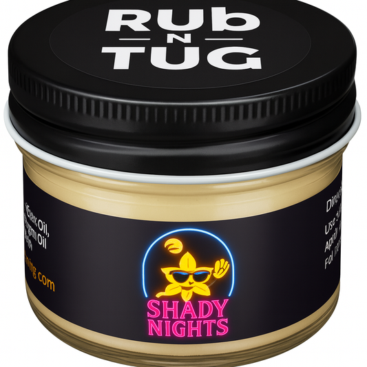 “A clear glass jar of Rub N Tug’s ‘Shady Nights’ all-natural pomade with a matte black lid featuring the brand’s bold white logo. The front label displays a neon-style graphic of a yellow flower with sunglasses waving under a palm tree moon scene, with the product name ‘Shady Nights’ in bright pink lettering. The cream-colored pomade inside is smooth and full, visible through the transparent sides of the jar. This organic pomade is made with jojoba oil, argan oil, beeswax, coconut oil and vitamin E oil.
